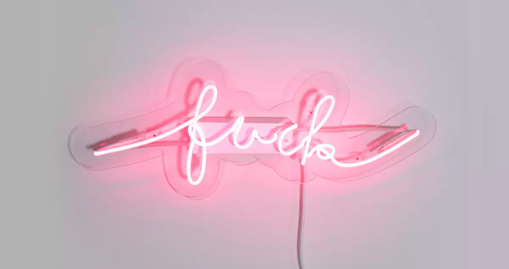 pink neon sign on transparent acrylic backplate that says