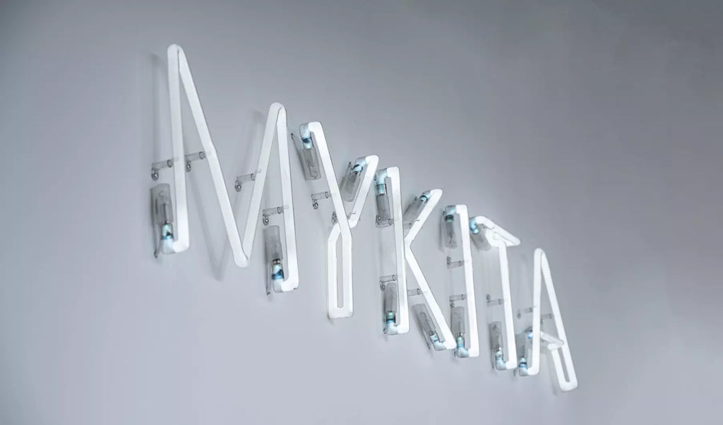 Mykita white neon logo direct-to-wall close-up shot