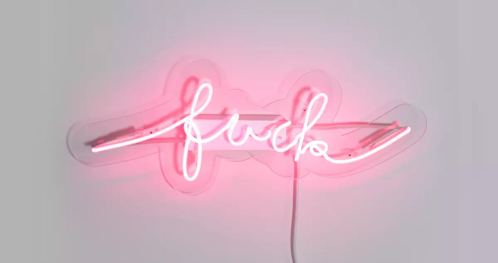 pink neon sign on transparent acrylic backplate that says 